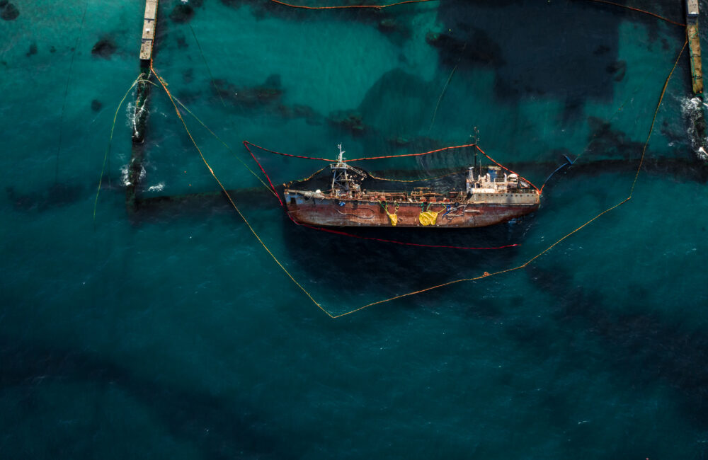 Top view of an old tanker that ran aground and overturned